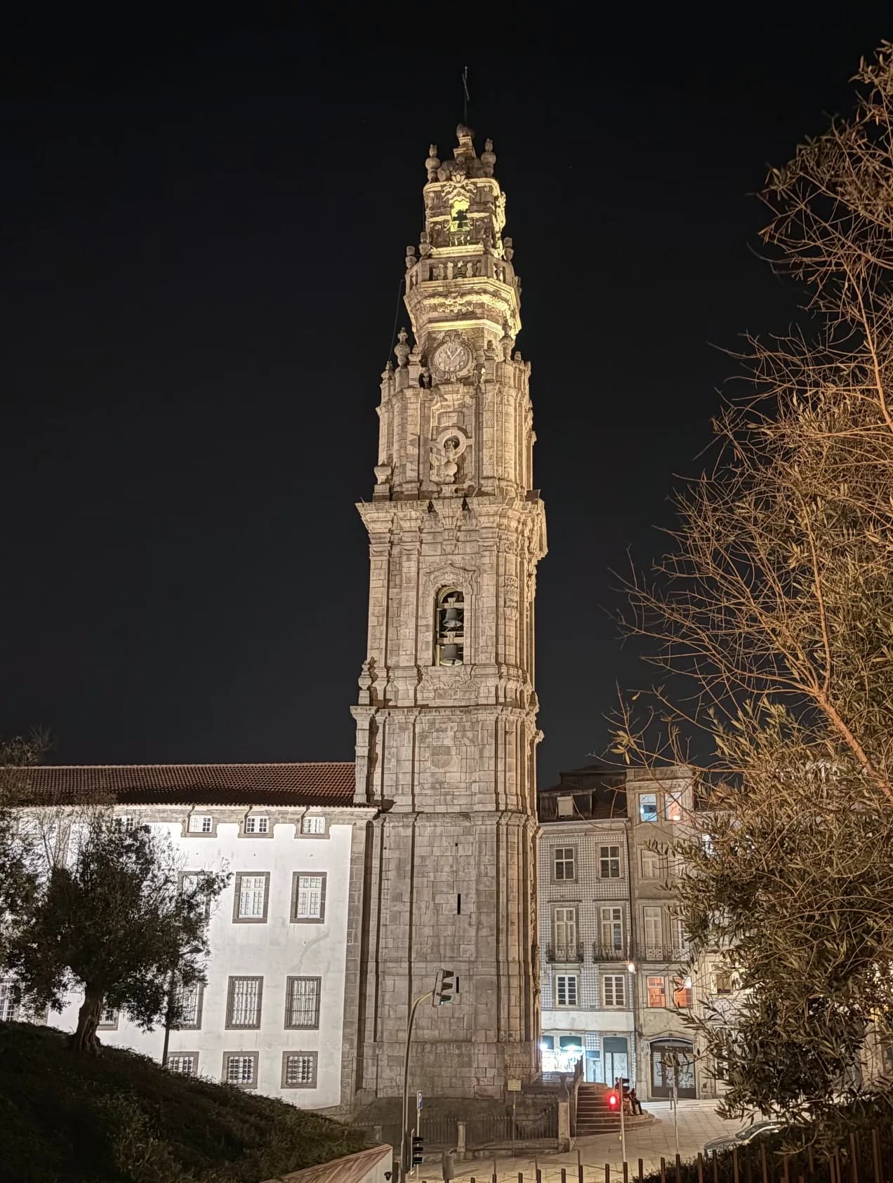 The Clérigos Tower lit against the night sky above the rooftops of Porto.