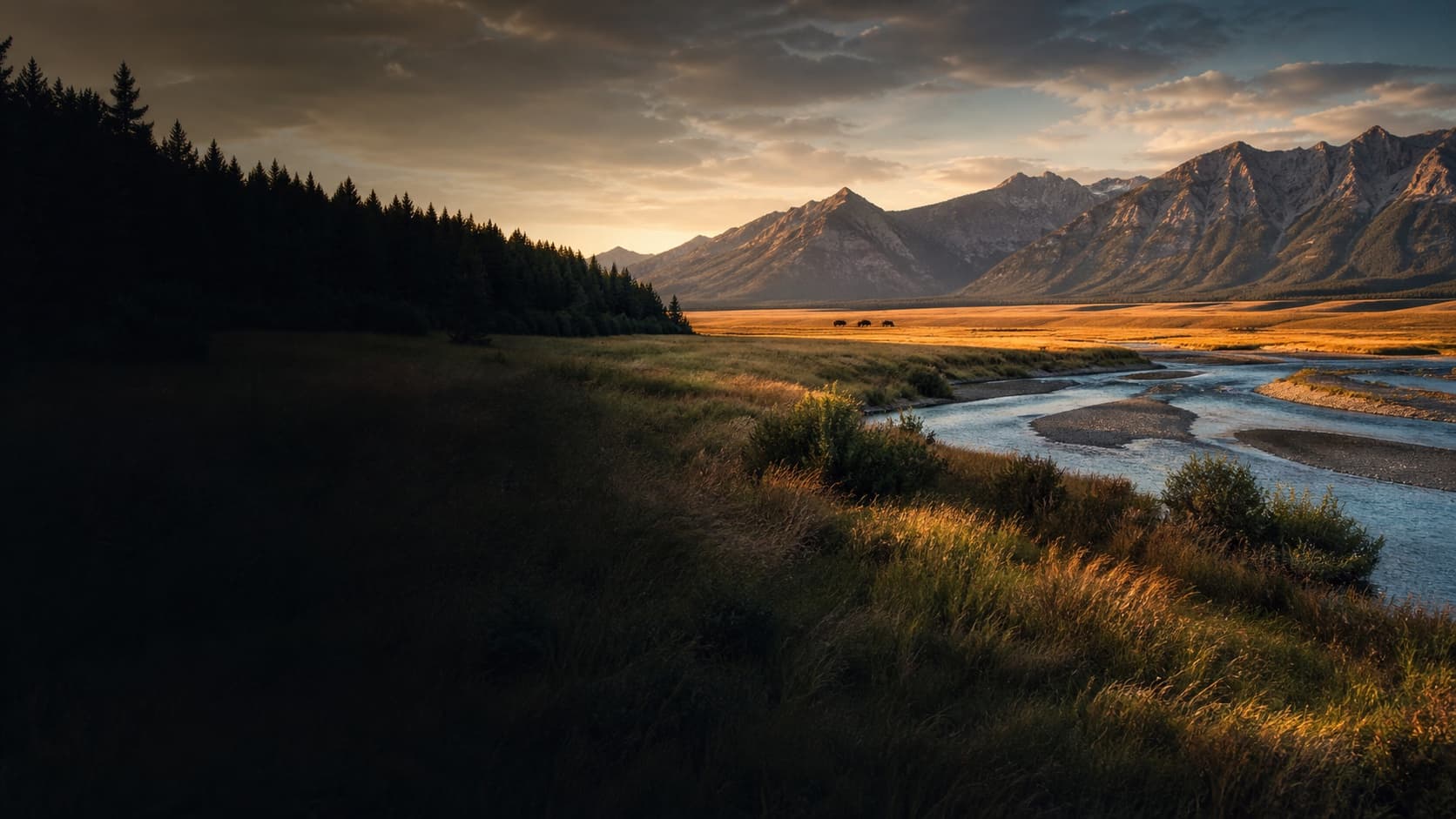 Prairie, river, and the northern Rocky Mountain Front in Montana at dawn.