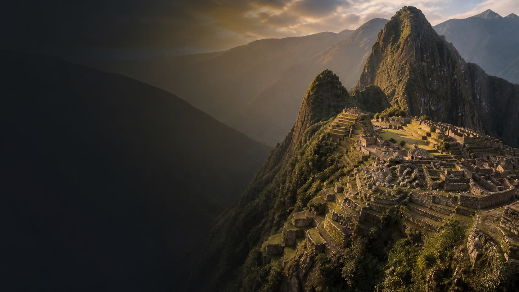 Machu Picchu and the layered Andes in warm dawn light.